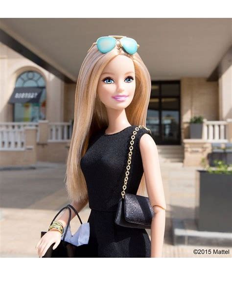 A Barbie Doll With Blonde Hair And Blue Eyes Holding A Purse In Front