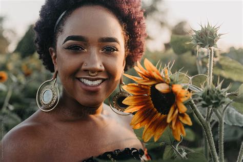 A Beautiful Young Black Woman Standing In A Field Of Flowers By