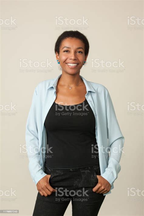 Studio Portrait Of An Attractive 30 Year Old Woman In A Blue Shirt On A
