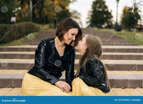 Mother And Daughter Together Look At Each Other And Get Married They Sit On The Stairs In The