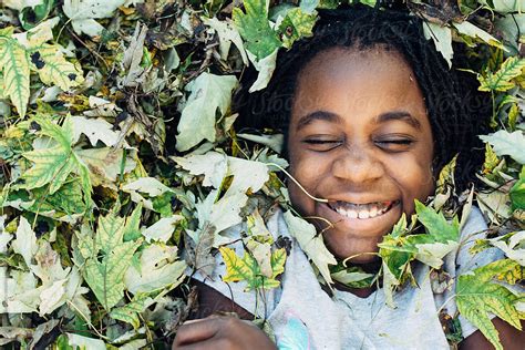 smiling african american girl in fall leaves del colaborador de stocksy gabi bucataru stocksy