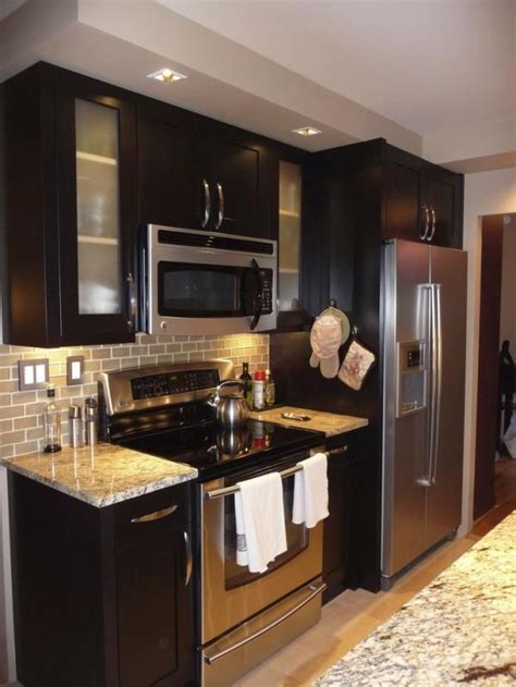Espresso Cabinets With Stainless Steel Appliances And Backsplash