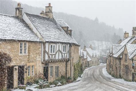 looking down the quintessential english village of castle combe in the snow wiltshire england