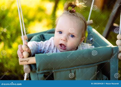 Cute Little Girl In The Swing Baby Swing On The Tree In The Garden
