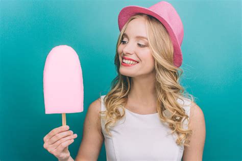 Delightful Girl Is Holding A Big Pink Ice Cream She Is Looking At It