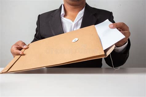 Businessman Open The Brown Envelope For Examining The Report On Table