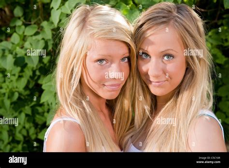 Close Up Portraits Of Two Beautiful Blond Teenage Girls Smiling Stock