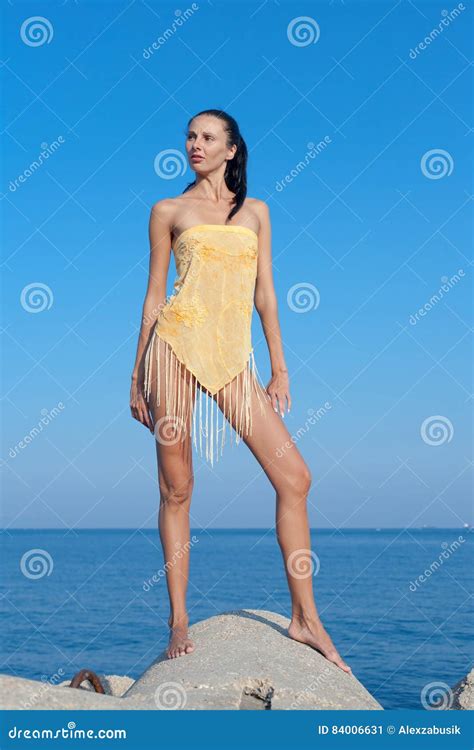 Dark Haired Young Woman In Pareo With Fringes Poses Outdoors Stock