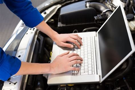 Premium Photo Mechanic Using Laptop On Car At The Repair Garage