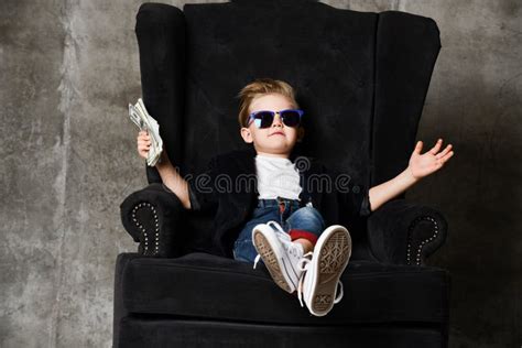 Arrogant Rich Boy Kid Millionaire Sits With Crossed Legs In Big Luxury