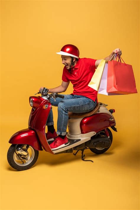 Repartidor Con Uniforme Amarillo En Moto Señalando Con El Dedo La Pizza