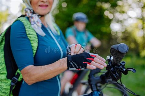 Close Up Of Senior Woman Biker Putting On Bicycle Gloves Stock Photo