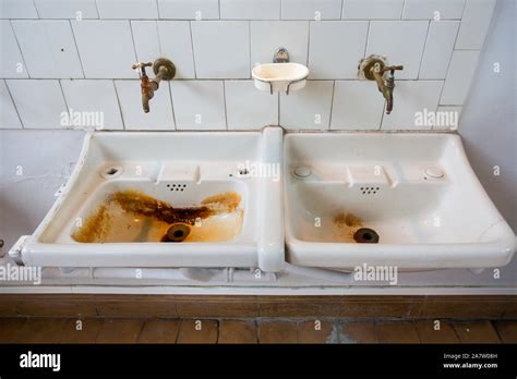 Two Dirty Sinks Wash Basins Covered In Rusty Stains In Bathroom Of