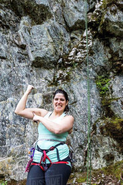 A Female Rock Climber Showing Off Her Muscles In Between Climbs On A