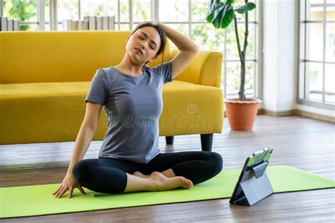Asian Woman Practicing Yoga Exercise At Begining Level From Online Lesson Playing On Laptop
