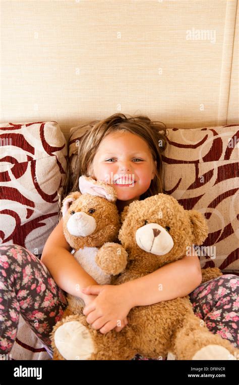 Girl Smiling Holding Teddy Bears And Cushions Stock Photo Alamy