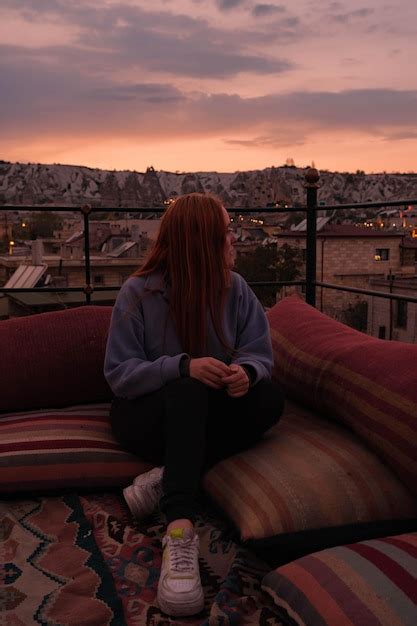 Premium Photo Girl Sitting On A Rooftop With Landscape Views