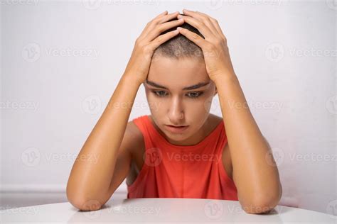 caucasian girl with short hair almost bald holds her hands behind her head 12965356 stock