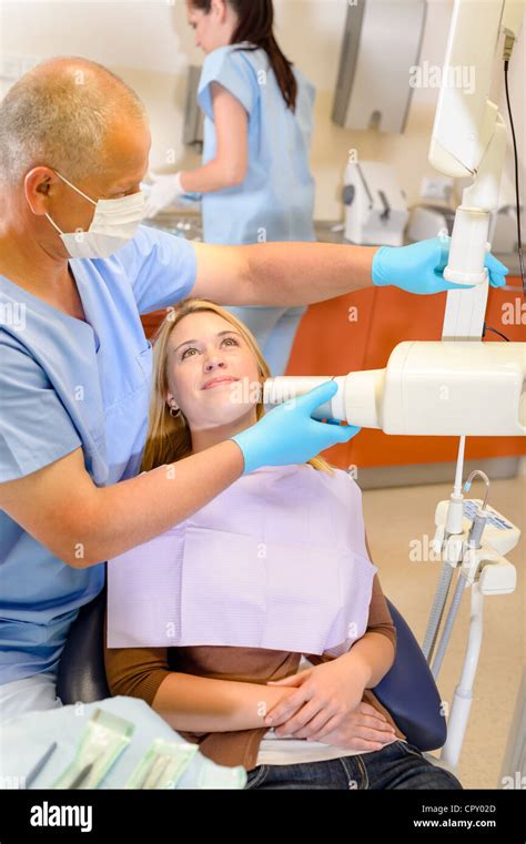 Dentist Taking X Ray Of Female Patient With Nurse Assistance Stock