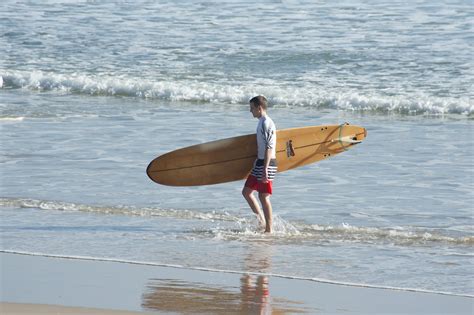 Free Image Of Surfer Walking Along The Waters Edge Freebiephotography
