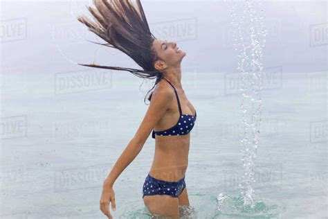Woman Tossing Wet Hair In Water Stock Photo Dissolve