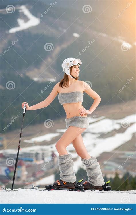 Sporty Naked Woman Is Posing On The Top Of The Slope With Skis Wearing Boots Helmet And