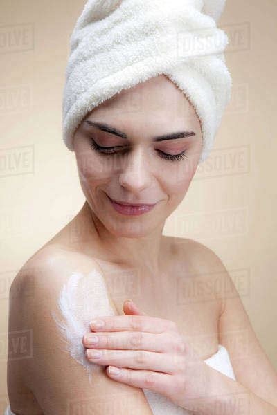 A Smiling Babe Woman Applying Lotion To Her Skin Stock Photo Dissolve