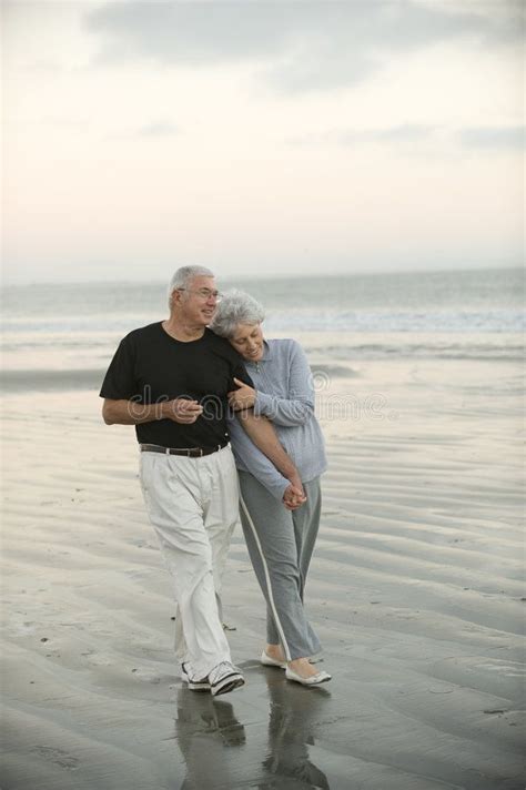 An Older Couple Walking On The Beach Together Royalty Photo Image And