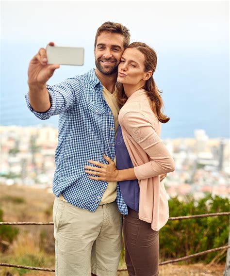 Sharing Some Selfie Love An Affectionate Couple Taking Selfies Outside