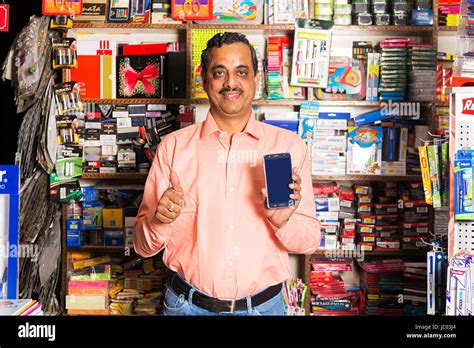 1 Indian Shopkeeper Man Thumbs Up Showing With Smart Phone In