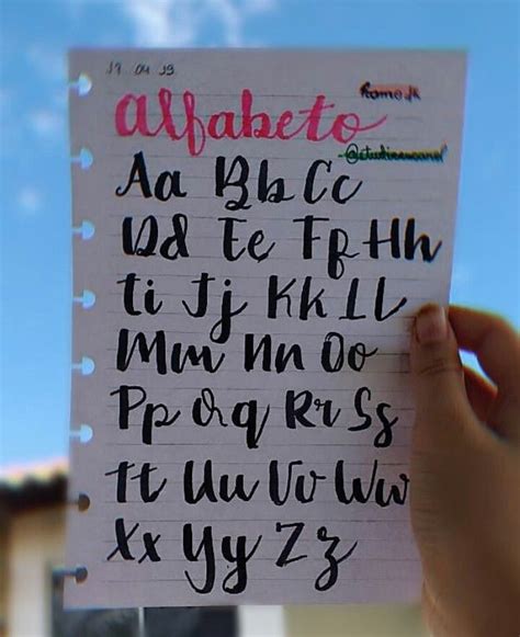 A Hand Holding Up A Piece Of Paper With Writing On It That Says Alphabets