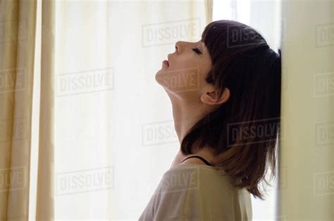 Portrait Of A Woman With Head Back Leaning Against A Wall Stock Photo Dissolve