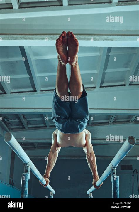 The Sportsman Performing Difficult Gymnastic Exercise At Gym The Sport