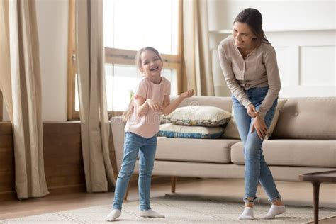 Happy Playful Cute Child Daughter Laughing Dancing With Young Mom Stock
