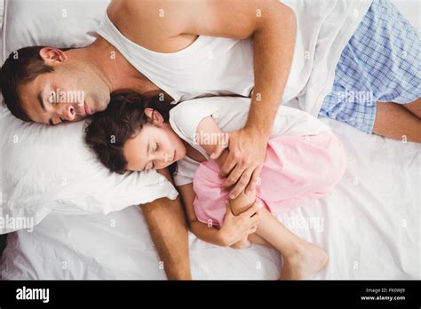 Father Sleeping With Daughter On Bed At Home Stock Photo Alamy