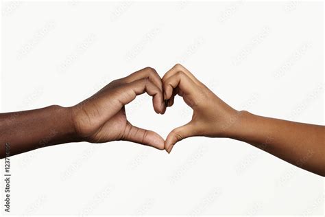 Two Young Dark Skinned People Holding Hands In Shape Of Heart