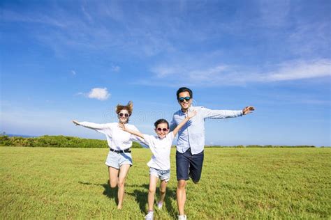 Familia Feliz Que Corre Junto En La Hierba Imagen De Archivo Imagen