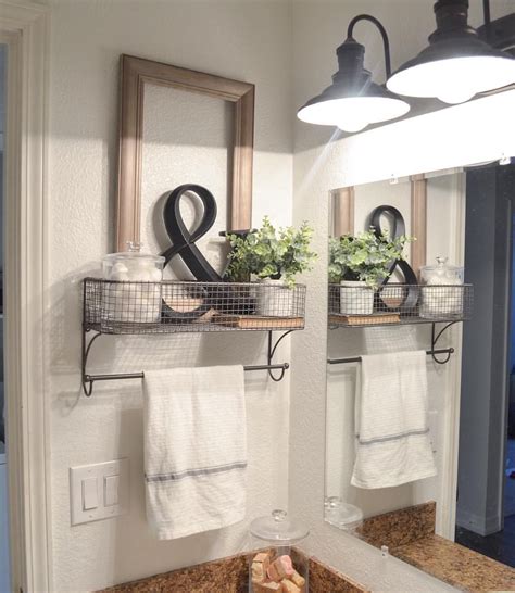 A Bathroom Sink With Two Towels Hanging On The Wall And Some Plants In