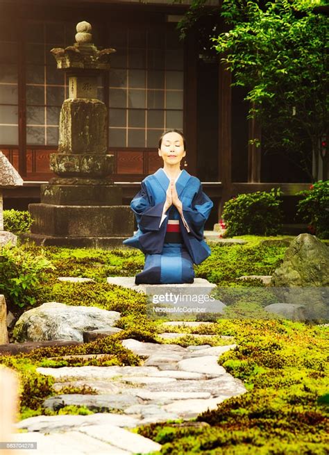 Japanese Mature Female In Kimono Meditates At Temple Garden Vertical