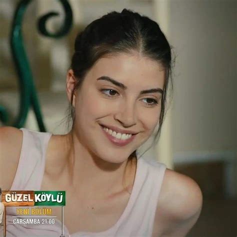 A Woman Smiling And Wearing A White Tank Top With The Words Guel Koylu On It