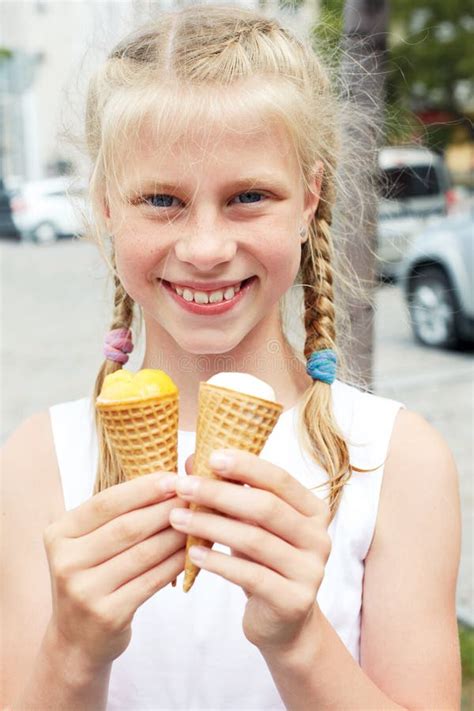Portrait Of 7 Years Old Kid Girl Eating Tasty Ice Cream In City Stock