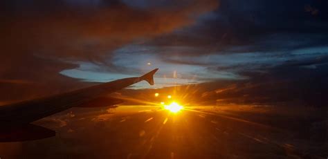 Aircraft Or Airplane Wing On Dark Sky With Sunset Light Flare