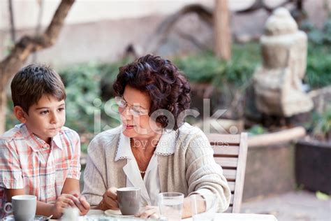 Abuela Hablando Con Su Nieto En El Coffeetable Fotografías De Stock