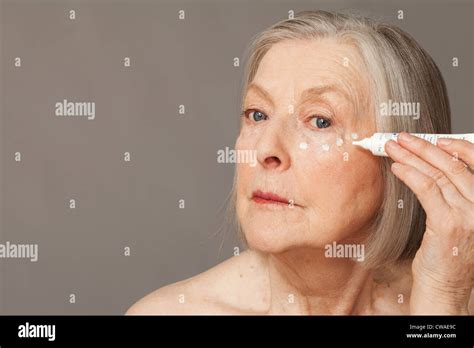 Senior Woman Applying Eye Cream Stock Photo Alamy