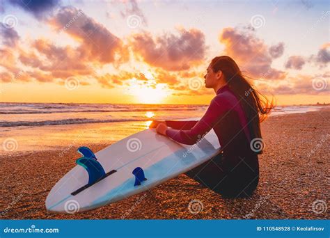 Surfer Girl On Sand Beach With Surfboard At Warm Sunset Or Sunrise