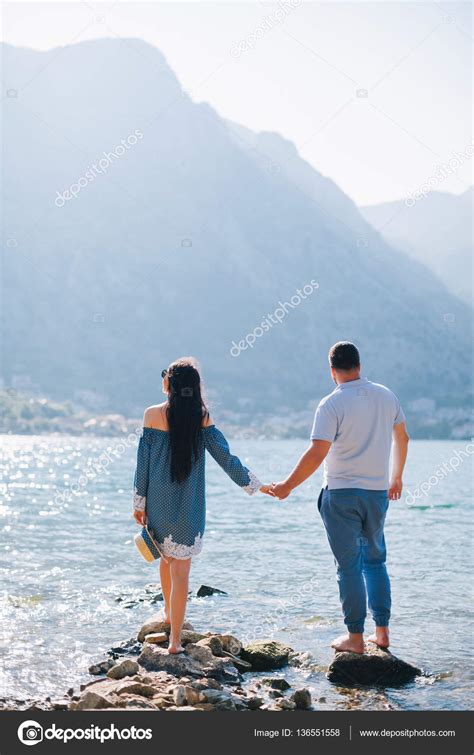 Romantic Couple Relax On Rocky Beach — Stock Photo © Shevtsovy 136551558