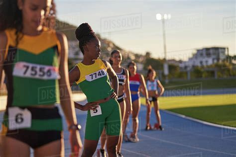 Female Track And Field Athletes Preparing At Starting Blocks On Track