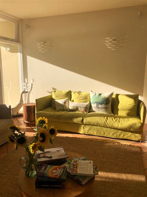 Sunlit Living Room With Green Yellow Couch Sunflowers And Rug How To