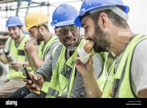 Construction Workers Having Lunch Break On Construction Site Stock