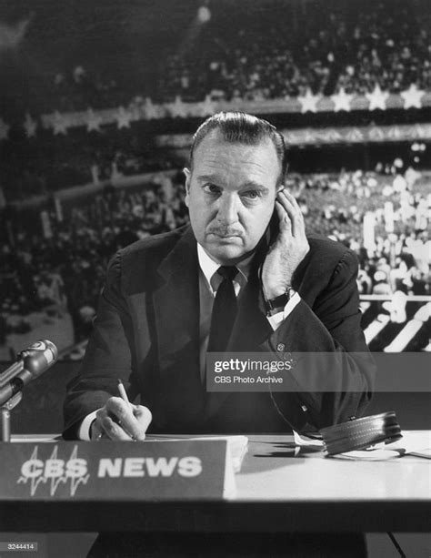 news correspondent walter cronkite sits behind a desk listening to news photo getty images